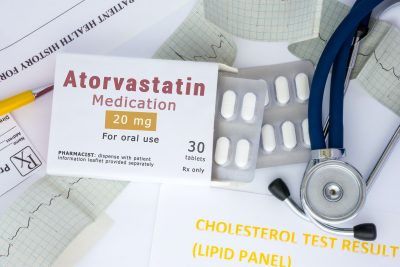 Atorvastatin pill pack next to a stethoscope and an electrocardiogram