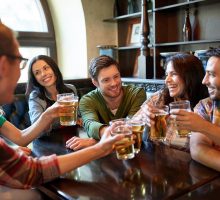 Young people around 20 to 30 partying and toasting at a bar